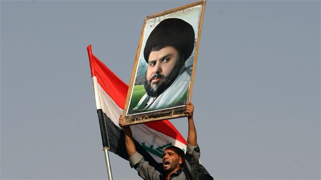 Iraqi protester holding up a portrait of Shia cleric Muqtada al-Sadr