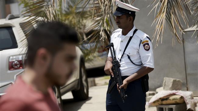 A member of the Bahraini security forces is seen at a checkpoint as Shia Muslims walk toward a mosque for Friday prayers in the village of Diraz, west of the capital, Manama, July 3, 201