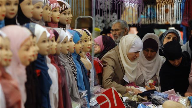 File photo shows women looking at veils, inside an exhibition hall during the 27th annual meeting of French Muslims, in Le Bourget, outside Paris
