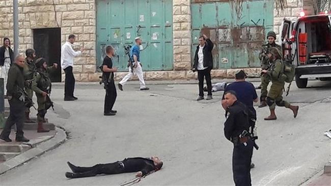 The photo shows the body of Abdel-Fattah al-Sharif lying on the ground. The Palestinian was fatally shot by an Israeli soldier in the West Bank city of al-Khalil, aka Hebron, March 24, 2016. (Photo by Ma’an)