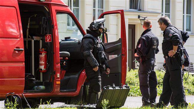 Officers of a special task force stand in front of an apartment building in Eisenhuettenstadt, eastern Germany, on August 17, 2016. (Photo by AFP)