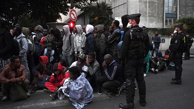 French officers secure the area as refugees wait and gather before being evacuated from a makeshift camp set up in Paris, September 16, 2016. (Photo by AFP)