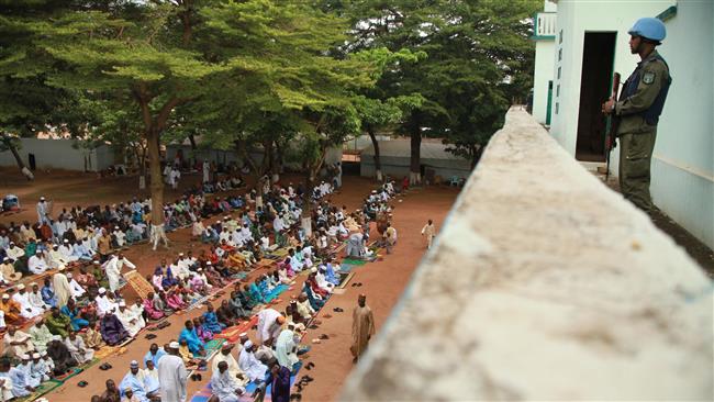 This file photo shows a member of the MINUSCA peacekeeping force standing guard while Muslims perform prayers at a mosque in Bangui, the Central African Republic. (By AFP)