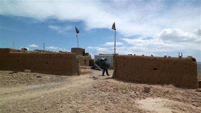 This picture taken on May 1, 2016 shows an Afghan policeman keeping watch at a police checkpoint on the Kandahar-Tirin Kot highway. (Photo by AFP)