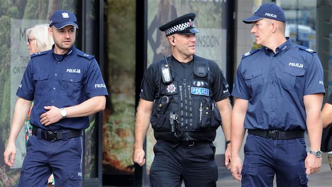 Polish police officers talk with Essex Police officer PC Paul Harrison (center) in Harlow, north of London, on September 15, 2016, as he patrols the neighborhood where a Polish man, Arkadiusz Jozwik was killed in a possible hate crime incident in August.(Photo by AFP)