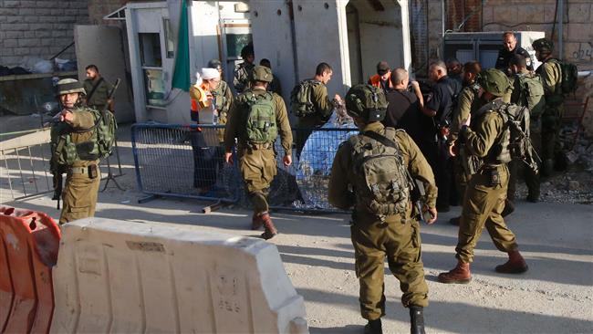 Israeli forces cover the body of a Palestinian who was shot dead near the illegal settler enclave of Tal Rumeda in al-Khalil (Hebron) in the occupied West Bank on September 16, 2016. (Photo by AFP)