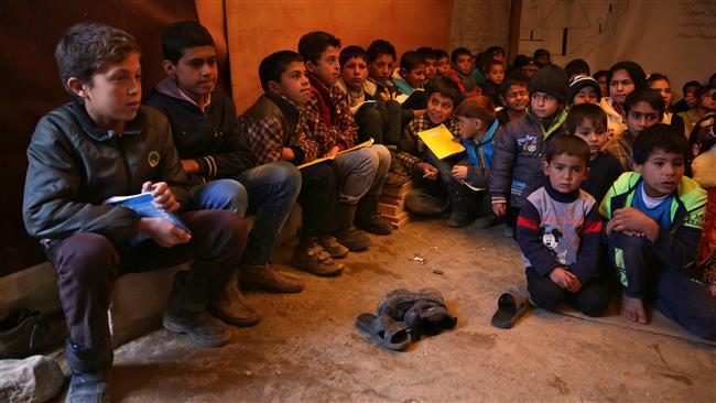 In this January 27, 2016 file photo, Syrian refugee children sit on the ground as they listen to their teacher inside a tent that has been turned into a makeshift school at a Syrian refugee camp in Qab Elias, a village in the Bekaa Valley, Lebanon. (By AP)