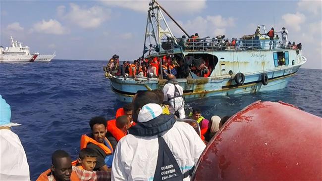 This video grab released on August 30, 2016, shows Italian coast guard personnel taking part in a rescue operation of a boat with refugees in the Mediterranean Sea. (Photo by AFP)