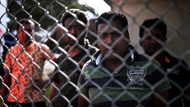 Bangladeshi refugees stand behind a fence of the Moria camp on the island of Lesbos, Greece, September 21, 2016. (Photo by AFP)