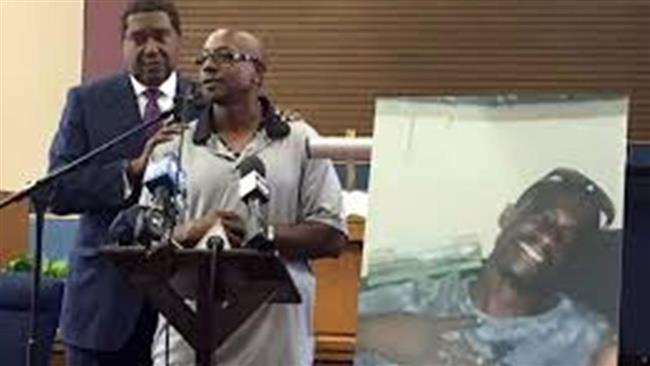 Robert Mann speaks next to a picture of Joseph, his brother, who was killed by police officer on July 11, 2016. (Photo from social media)