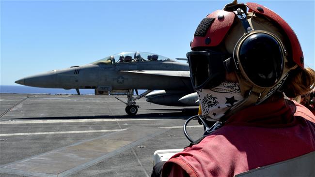 A picture taken on July 6, 2016 shows a sailor looking at an F/A-18F Super Hornet taxiing on the US Navy’s super carrier USS Dwight D. Eisenhower, deployed in the Mediterranean in support of the US-led operations in Syria and Iraq. (Via AFP)