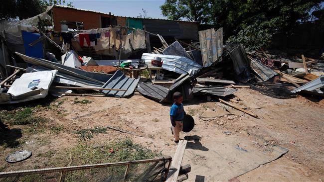 A child from the Arab Jahalin Bedouin community walks past the debris of his family house in the central West Bank village of al-Khan al-Ahmar, April 6, 2016. The house was earlier demolished by Israeli forces. (Photo by AFP)
