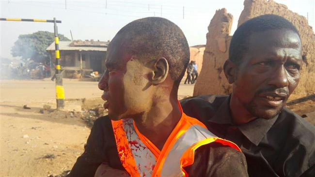 A bloodied mourner is being helped by a resident in the northwestern Nigerian city of Funtua on October 12, 2016.