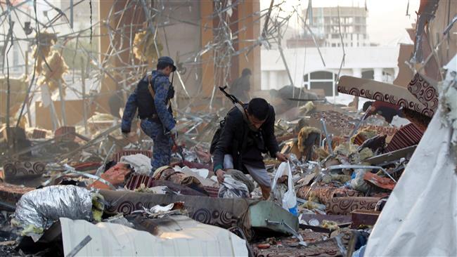 A Yemeni collects data-x-items amidst the rubble of a destroyed building following airstrikes by Saudi-led coalition airplanes on the capital Sana