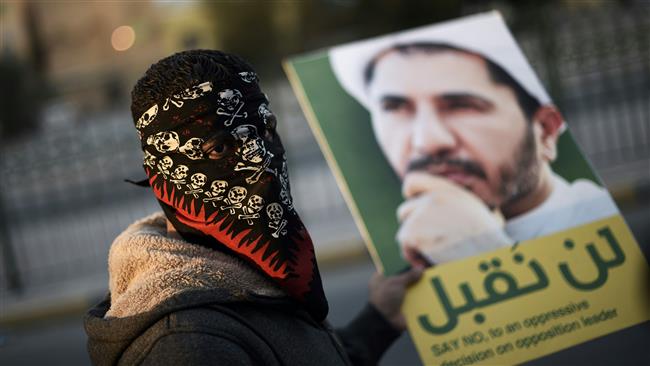 A Bahraini protester holds a placard bearing a portrait of Sheikh Ali Salman, during clashes with riot police following a protest against his arrest in the village of Sitra, south of the capital, Manama, January 29, 2016. (Photo by AFP)