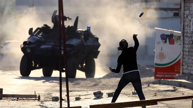 A protester throws a glass bottle containing paint at a police armored personnel carrier during anti-regime clashes in the village of Sitra, south of Manama, on February 14, 2016. (Photo by Reuters)