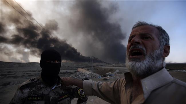 A Sunni fighter from the Popular Mobilization Units is welcomed by an Iraqi man at a checkpoint east of Mosul, as displaced Iraqi families flea areas of unrest, on October 22, 2016, during an operation to retake the strategic city from the Daesh Takfiri terrorist group. (Photo by AFP)