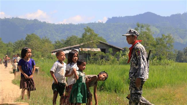 In this photograph taken on October 21, 2016 Myo ethnic children looks at a Myanmar border police in LaungDon, located in Rakhine State. (Photo by AFP)