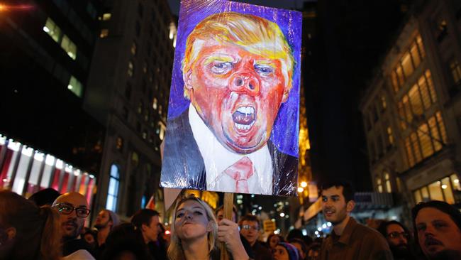A woman holds a poster as she takes part in a protest against President-elect Donald Trump in New York City on November 9, 2016. (Photo by AFP)