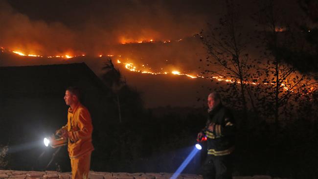 Fires burn in the horizon as firefighters battle to control the blazes in Nataf in the Israeli-occupied territories on November 25, 2016. (Photo by AFP)