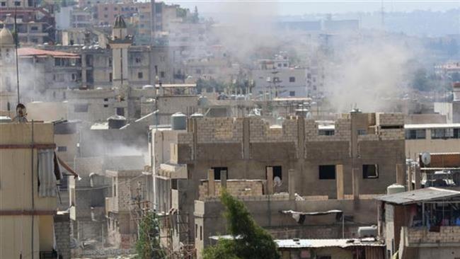 Smoke billows from buildings at the Ain El-Helweh Palestinian refugee camp near Lebanon’s southern port city of Sidon on August 23, 2015, a day after three people were killed in fierce clashes there. (Photo by AFP)