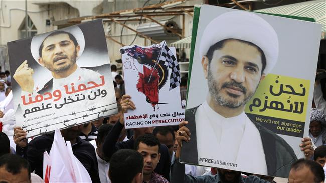 Bahraini anti-regime protesters carry portraits of Sheikh Ali Salman, the head of the opposition al-Wefaq National Islamic Society, during a demonstration, April 1, 2016, in Diraz village. (Photo by AP)