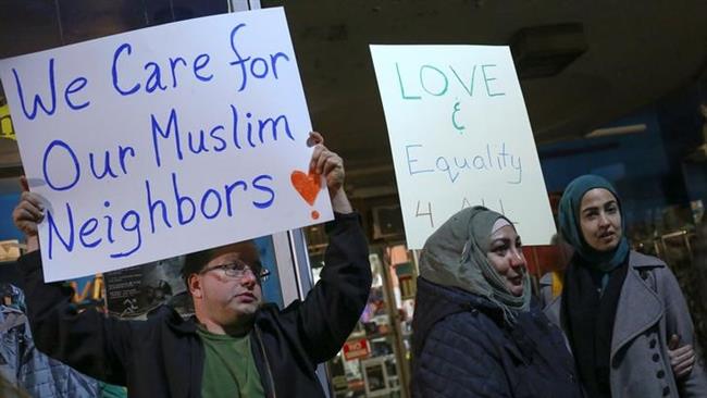 Protesters hold signs during a demonstration against Donald Trump and in support of Muslim residents in Hamtramck, Michigan.