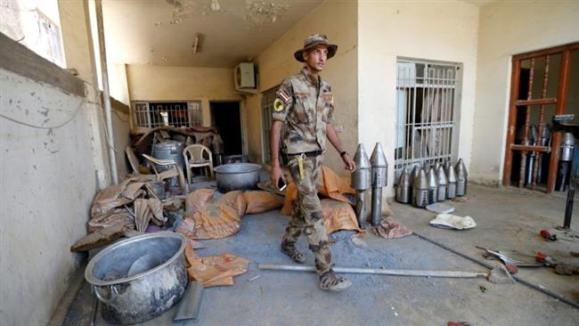 In this file photo, a member of the Iraqi counter-terrorism forces walks by Daesh weapons factory in Fallujah, Iraq. (By Reuters)