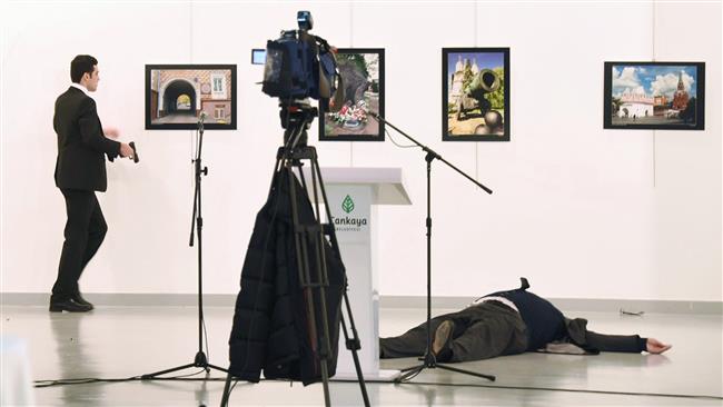 Picture taken on December 19, 2016 shows Andrey Karlov (R), the Russian ambassador to Ankara, lying on the floor after being shot by Mevlut Mert Altintas (L), who is removing pictures from the wall, during an attack during a public event in Ankara. (By AFP)