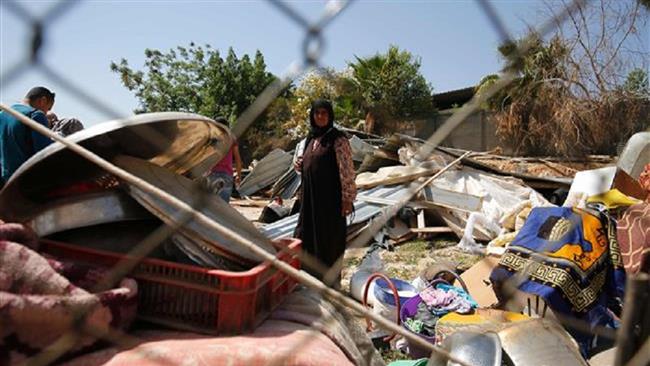 A woman stands amid the debris of homes in the West Bank Bedouin camp of al-Khan al-Ahmar after Israeli authorities demolished four houses there, April 7, 2016. (Photo by AFP)