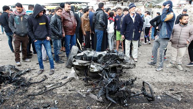 Iraqis inspect a charred vehicle on the site of a terrorist bomb attack in Sadr City in the north of the capital, Baghdad, on January 2, 2017. (Photo by AFP)