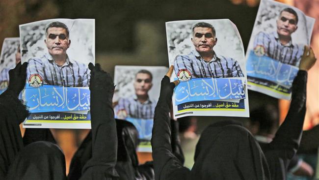 Bahraini anti-regime protesters hold up images of human rights activist Nabeel Rajab during a solidarity demonstration outside his home in the village of Bani Jamra, Bahrain, May 14, 2015. (Photo by AP)