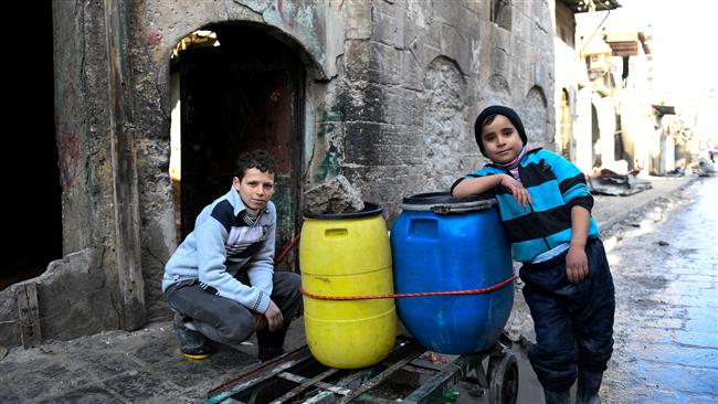 This handout picture provided by UNHCR on January 4, 2017 shows Syrian boys beside a cart they use to carry water back to their home in an east Aleppo neighborhood. (Photo by Reuters)