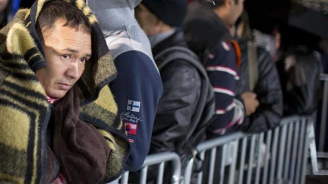 Refugees line up on the grounds of the State Office of Health and Social Affairs, where they wait for their registration, in Berlin, Germany