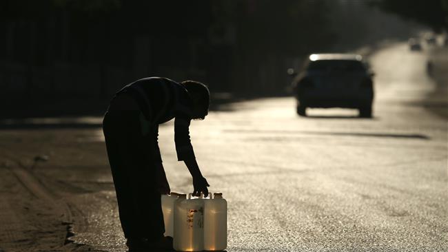 A Palestinian boy carries water in plastic canisters on a main road in Beit Lahia in the northern Gaza Strip, on November 8, 2016. (Photo by AFP)