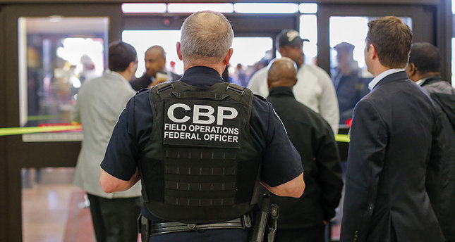 A Customs and Border Protection (CBP) federal officer watches from inside the terminal during a protest at Hartsfield-Jackson Atlanta International Airport