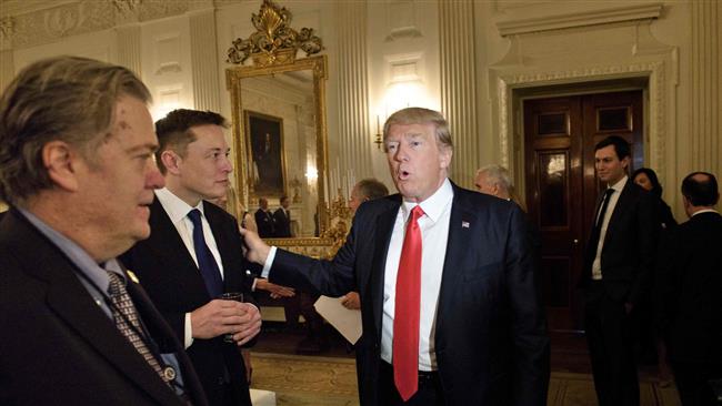 Trump advisor Steve Bannon (L) watches as US President Donald Trump greets Elon Musk, SpaceX and Tesla CEO, before a policy and strategy forum with executives in the State Dining Room of the White House on February 3, 2017 in Washington, DC. (Photo by AFP)