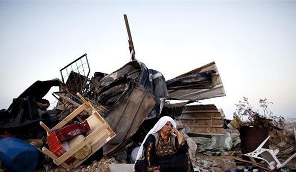 Palestinian woman in front of her house which is demolished by Israeli Forces