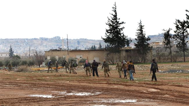 Turkey-backed militants walk with their weapons in the northeastern outskirts of the Syrian city of al-Bab in Aleppo Province, on February 15, 2017. (Photo by AFP)