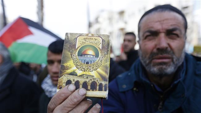 A Palestinian protester holds a Holy Quran with the Dome of the Rock Mosque in the al-Aqsa Mosque compound in the Old City of occupied East Jerusalem al-Quds, in the West Bank city of Ramallah, January 19, 2017. (Photo by AP)
