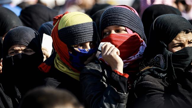 Refugee women who fled the Iraqi city of Mosul wait in a queue for aid at the UN-run al-Hol refugee camp in Syria