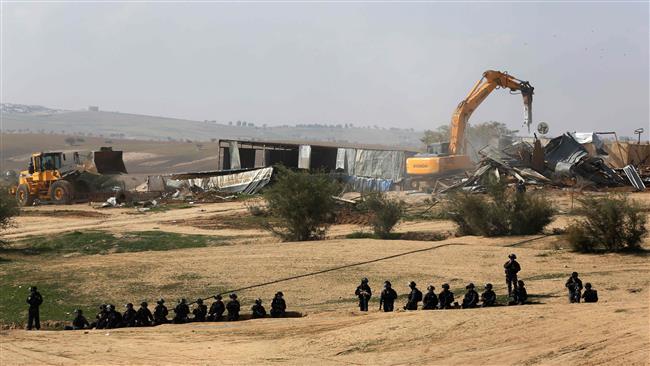 Israeli security forces stand guard as bulldozers demolish homes in the Bedouin village of Umm al-Hiran, near the southern city of Beersheba, in the Negev desert, on January 18, 2017. (Photo by AFP)