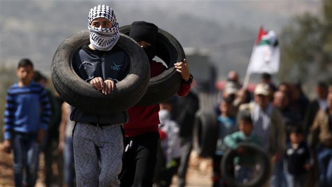 Palestinian protesters carry tires during a weekly demonstration against the expropriation of Palestinian land by Israel in the town of Kfar Qaddum, near Nablus, in the occupied West Bank on February 24, 2017. (Photo by AFP)