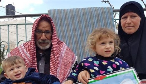 The photo shows the parents of Palestinian Fadi al-Qanbar and two of his children.