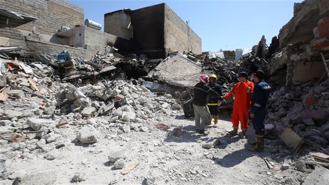 Iraqi civilians and rescue workers inspect the damage in Mosul