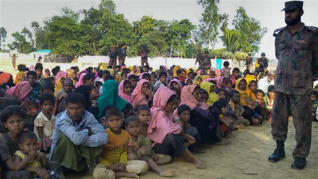 Rohingya Muslims from Myanmar, who tried to cross the Naf river into Bangladesh to escape sectarian violence, are kept under watch by Bangladeshi security officials in Teknaf on December 25, 2016. (Photo by AFP)