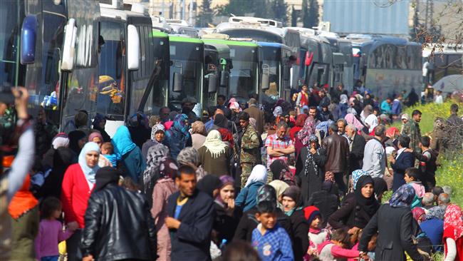 People that were evacuated from the two villages of Kefraya and al-Foua walk near buses at militant-held al-Rashideen, Aleppo Province, Syria, on April 15, 2017. (Photo by Reuters)