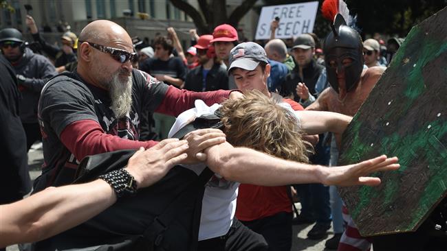 A man gets hit as multiple fights break out between Trump supporters and anti-Trump protesters in Berkeley, California on April 15, 2017. (Photo by AFP)