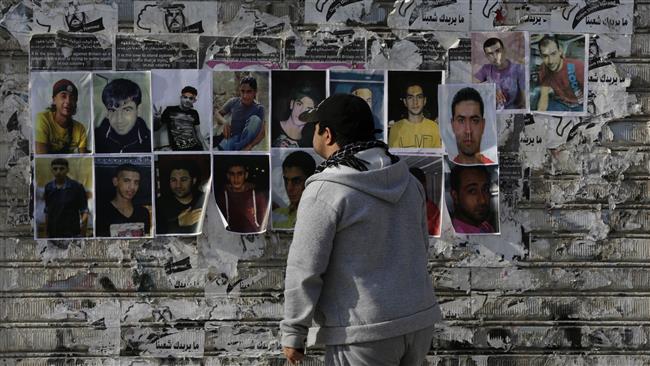 A Bahraini man looks at pictures of jailed activists tacked to a wall layered with anti-regime graffiti during a protest march in Sitra, February 12, 2016. (Photo by AP)