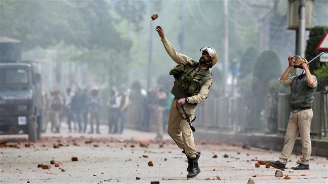 A member of Indian security forces throws a stone during clashes with Kashmiri students in Srinagar, April 24, 2017. (Photo by AFP)